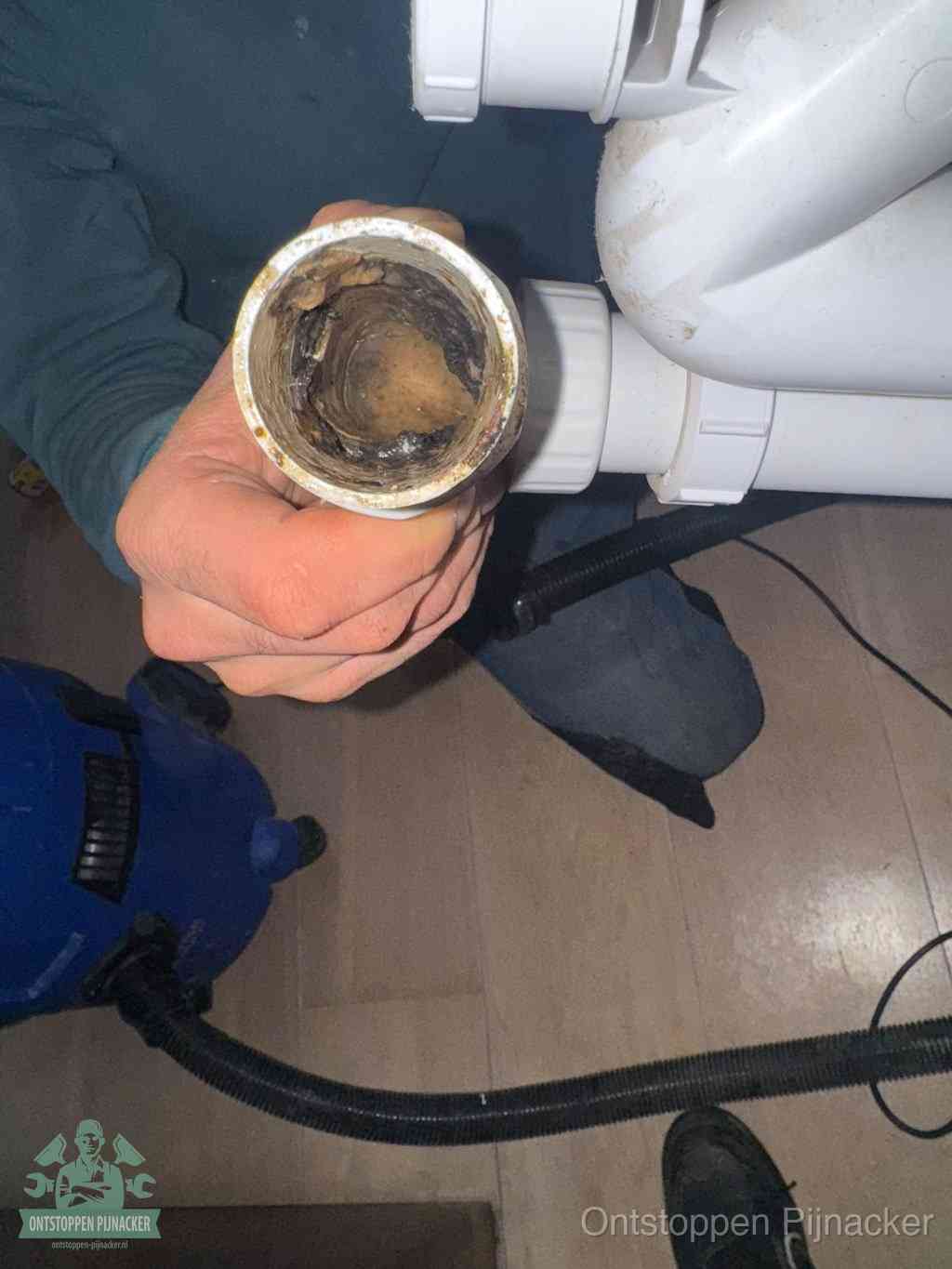 Een losgekoppeld afvoerbuisstuk dat van binnen volledig is dichtgeslibd, het gevolg van een verstopping te lang laten zitten in Pijnacker