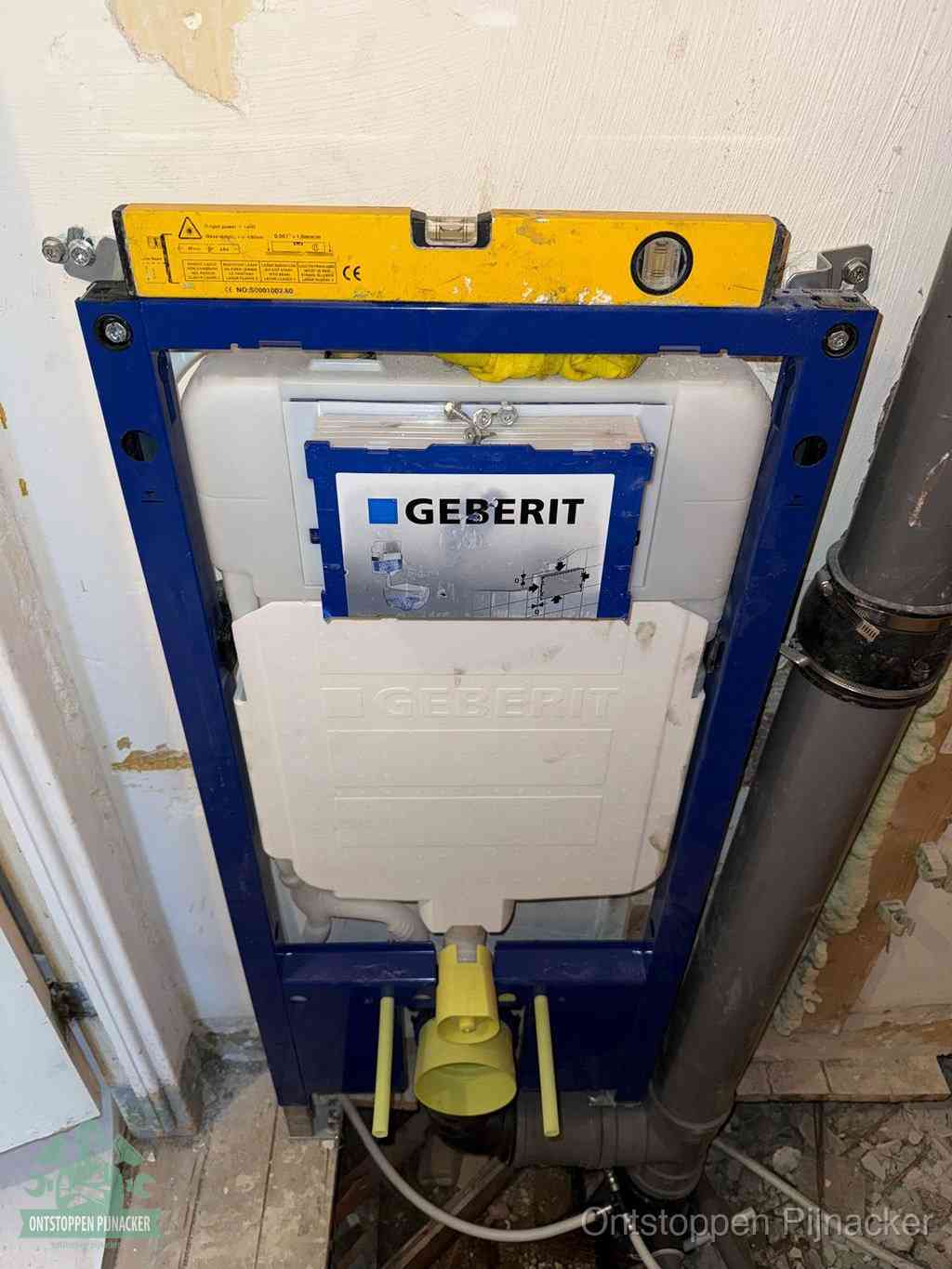Een Geberit inbouwreservoir met frame voor een hangtoilet tegen de wand, met de afvoerbocht naar de vloer, kenmerkend voor een verstopt hangtoilet in Pijnacker