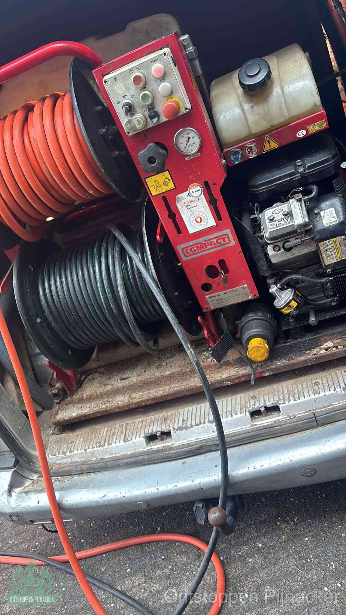 Een rood hogedruk-rioolreinigingstoestel met slangen in de laadbak van de bedrijfsbus, apparatuur voor een hardnekkige wc-verstopping in Pijnacker