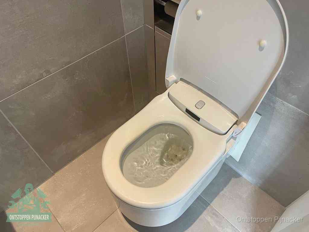 Een toiletpot vol troebel water met drijvend papier en restanten, de meest voorkomende oorzaak van een verstopte wc in Pijnacker