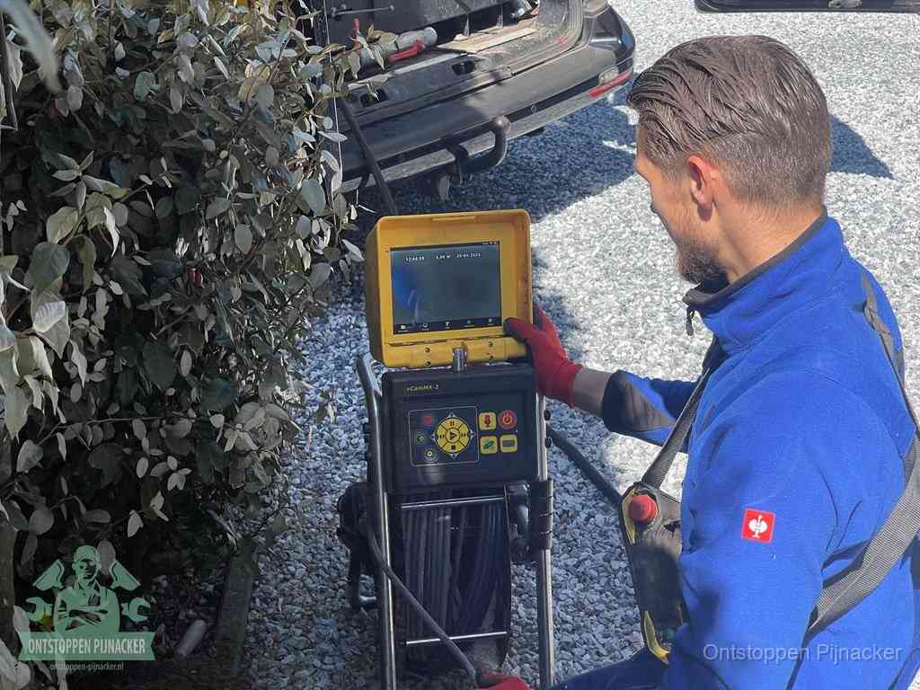Monteur bedient een rioolinspectiecamera met monitor voor rioolinspectie in Pijnacker