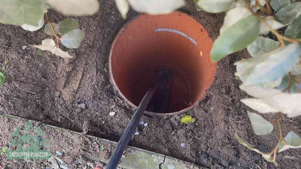 Open inspectieput in de tuin waar een veer rioolvliegjes en stankoverlast aanpakt in Pijnacker